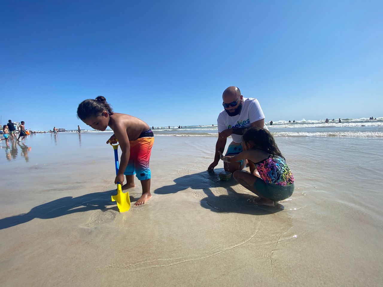 Jordan Cruz and his children play along the shore of Daytona Beach. (Spectrum News/Molly Duerig)